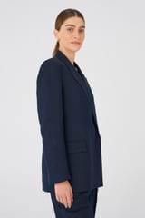 Profile view of model wearing the Oroton Double Breasted Blazer in North Sea and 58% Viscose, 42% Linen for Women