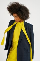 Profile view of model wearing the Oroton Sleeveless High Neck Top in Vivid Yellow and 92% silk, 8% spandex for Women