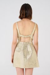 Profile view of model wearing the Oroton Metallic Mini Dress in Gold and 5% polyamide, 37.4% polyester, 24.4% metallised polyester, 33.2% viscose for Women