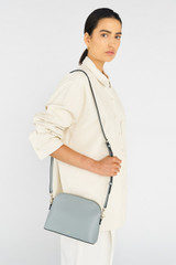 Profile view of model wearing the Oroton Inez Slim Crossbody in Greystone and Saffiano Leather for Women