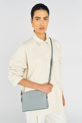 Profile view of model wearing the Oroton Inez Slim Crossbody in Greystone and Saffiano Leather for Women