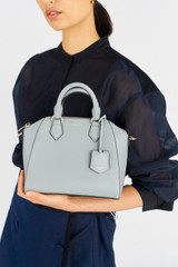 Profile view of model wearing the Oroton Inez Mini Day Bag in Greystone and Saffiano Leather for Women