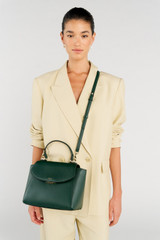 Profile view of model wearing the Oroton Inez Medium Satchel in Juniper and Saffiano Leather for Women