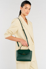 Profile view of model wearing the Oroton Inez Small Satchel in Juniper and Saffiano Leather for Women