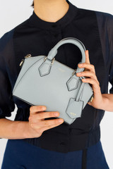 Profile view of model wearing the Oroton Inez Tiny Day Bag in Greystone and Saffiano Leather for Women