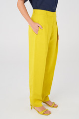 Profile view of model wearing the Oroton Pleat Pant in Vivid Yellow and 58% Viscose, 42% Linen for Women