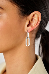 Profile view of model wearing the Oroton Isla Link Charm Hoop in Silver and Brass for Women