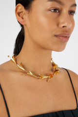 Profile view of model wearing the Oroton Lilium Necklace in Shiny Gold and Brass for Women