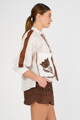 Profile view of model wearing the Oroton Embroidered Tulip Top in White/Chocolate and 100% linen for Women