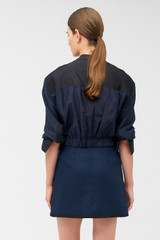 Profile view of model wearing the Oroton Cropped Colour Block Dinner Shirt in North Sea/Black and Main: 68% cotton, 32% silk. Contrast: 100% cotton for Women