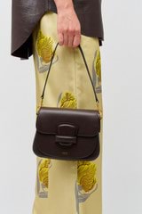 Profile view of model wearing the Oroton Carter Small Day Bag in Mahogany and Smooth leather for Women