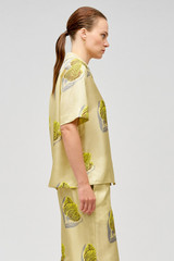 Profile view of model wearing the Oroton Linear Tulip Camp Shirt in Fennel and 100% silk for Women