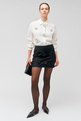 Profile view of model wearing the Oroton Flower Sequin Mini Skirt in Black and 100% linen for Women