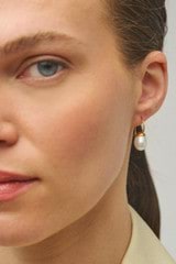 Profile view of model wearing the Oroton Bonnie Tear Drop Bead Earrings in Gold/Pearl and Sustainably sourced 925 Sterling Silver for Women