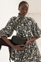 Profile view of model wearing the Oroton Juniper Print Short Dress in Black and 100% silk for Women