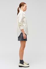 Profile view of model wearing the Oroton Poplin Long Sleeve Shirt in Cream and 100% cotton for Women