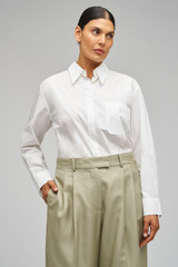 Profile view of model wearing the Oroton Poplin Long Sleeve Shirt in Cream and 100% cotton for Women