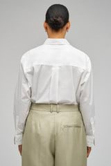 Profile view of model wearing the Oroton Poplin Long Sleeve Shirt in Cream and 100% cotton for Women