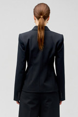 Profile view of model wearing the Oroton Shaped Double Breasted Blazer in Black and 53% polyester, 42% virgin wool, 5% elastane for Women
