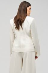 Profile view of model wearing the Oroton Shaped Double Breasted Blazer in Milk and 53% polyester, 42% virgin wool, 5% elastane for Women