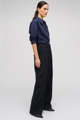 Profile view of model wearing the Oroton Slouch Pant in Black and 53% polyester, 42% virgin wool, 5% elastane for Women