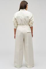Profile view of model wearing the Oroton Slouch Pant in Milk and 53% polyester, 42% virgin wool, 5% elastane for Women