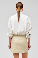 Profile view of model wearing the Oroton Flower Sequin Mini Skirt in Limestone and 100% linen for Women