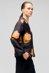 Profile view of model wearing the Oroton Linear Tulip Print Long Sleeve Camp Shirt in Black and 100% silk for Women