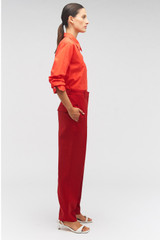 Profile view of model wearing the Oroton Pleat Pant in Cerise and 50% wool, 50% recycled polyester for Women