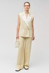 Profile view of model wearing the Oroton Sleeveless Waiter's Jacket in Limestone and 58% viscose, 42% linen for Women