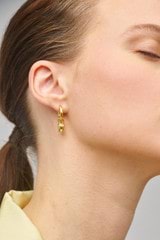 Profile view of model wearing the Oroton Bonnie Tulip Charm in Gold and 100% Recycled Sterling Silver for Women
