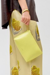 Profile view of model wearing the Oroton Mia Texture Pouch in Sicily Yellow and Textured leather for Women