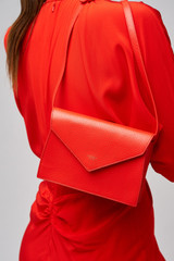 Profile view of model wearing the Oroton Mia Texture Clutch in True Red and Textured leather for Women