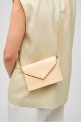 Profile view of model wearing the Oroton Mia Texture Clutch in Honey Nougat and Textured leather for Women
