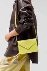 Profile view of model wearing the Oroton Mia Texture Clutch in Sicily Yellow and Textured leather for Women