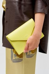 Profile view of model wearing the Oroton Mia Texture Clutch in Sicily Yellow and Textured leather for Women