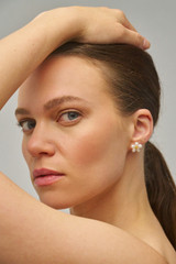 Profile view of model wearing the Oroton Posie Flower Studs in Gold/Pearl and Freshwater pearl for Women