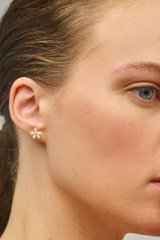 Profile view of model wearing the Oroton Posie Mini Flower Studs in Gold/Pearl and Freshwater pearl for Women
