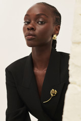 Profile view of model wearing the Oroton Tulip Brooch in Gold and Brass for Women