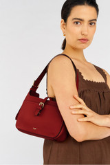 Profile view of model wearing the Oroton Dylan Baguette in Dark Ruby and Pebble Leather for Women