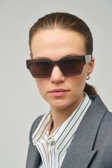 Profile view of model wearing the Oroton Stevie Sunglasses in Soot and Acetate for Women
