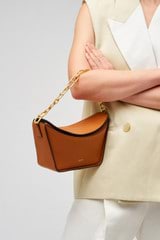 Profile view of model wearing the Oroton Fable Small Day Bag in Amber and Smooth leather for Women