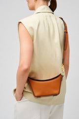 Profile view of model wearing the Oroton Fable Small Day Bag in Amber and Smooth leather for Women