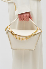 Profile view of model wearing the Oroton Fable Small Day Bag in Paper White and Smooth leather for Women