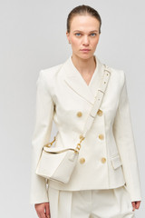 Profile view of model wearing the Oroton Fable Small Day Bag in Paper White and Smooth leather for Women