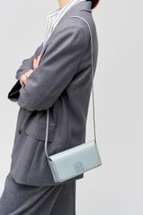 Profile view of model wearing the Oroton Della Texture Small Baguette in Dusk Blue and Textured leather for Women