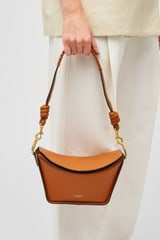 Profile view of model wearing the Oroton Florence Bag Strap in Cognac and Smooth leather for Women