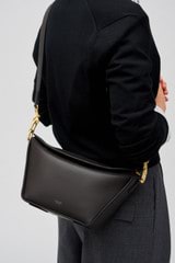 Profile view of model wearing the Oroton Fable Day Bag in Black and Smooth leather for Women