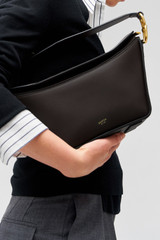 Profile view of model wearing the Oroton Fable Day Bag in Black and Smooth leather for Women