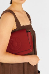 Profile view of model wearing the Oroton Polly Crossbody in Dark Ruby and Pebble leather for Women